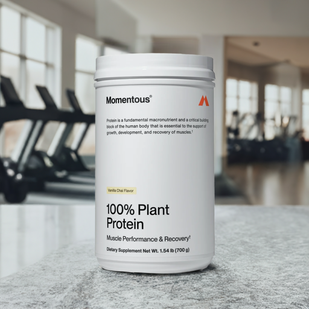 Momentous 100% Plant Protein Vanilla Chai displayed in fitness studio, perfect for gluten-free and vegan protein supplementation.