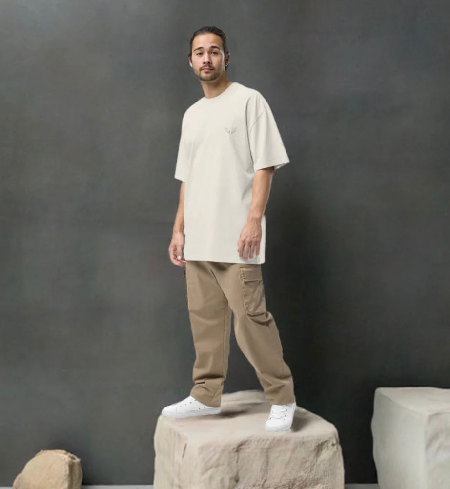 Model wearing Velite Armor Oversized Embroidered Tee – Premium Heavyweight in off-white, styled with cargo pants and white sneakers.