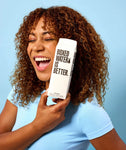 Boxed Water 500 ml – Pure & Sustainable Carton Packaging held by smiling woman, highlighting joyful lifestyle and sustainable hydration choice.