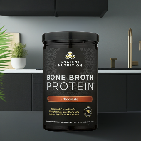 Equip Prime Protein Chocolate powder tub on a modern kitchen counter, featuring a sleek black and gold label design.
