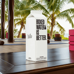 Boxed Water 500 ml – Pure & Sustainable Carton Packaging on a wooden surface near yoga mats and palm trees, ideal for eco-conscious wellness routines.