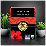 Hibiscus Tea front label next to indoor green plants, promoting calm and antioxidant-rich herbal benefits

