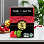 Organic Raspberry Leaf Tea box on kitchen counter surrounded by fresh raspberries and herbal decor for feminine health

