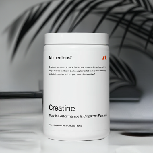 Momentous Creatine supplement container on a modern surface, designed to support muscle performance and cognitive function with Creapure®.