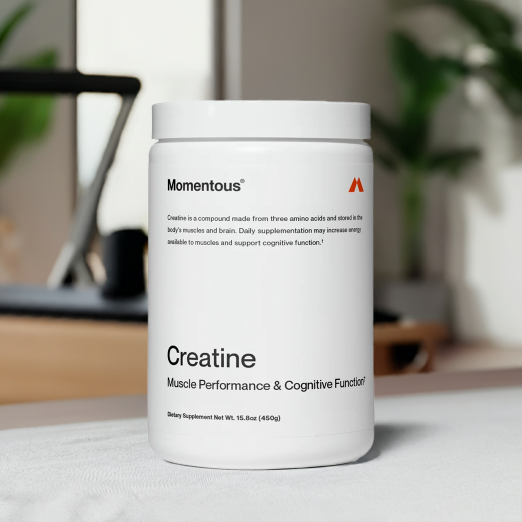 Momentous Creatine jar in a home gym setting, promoting its use for muscle and brain performance enhancement with clean ingredients.