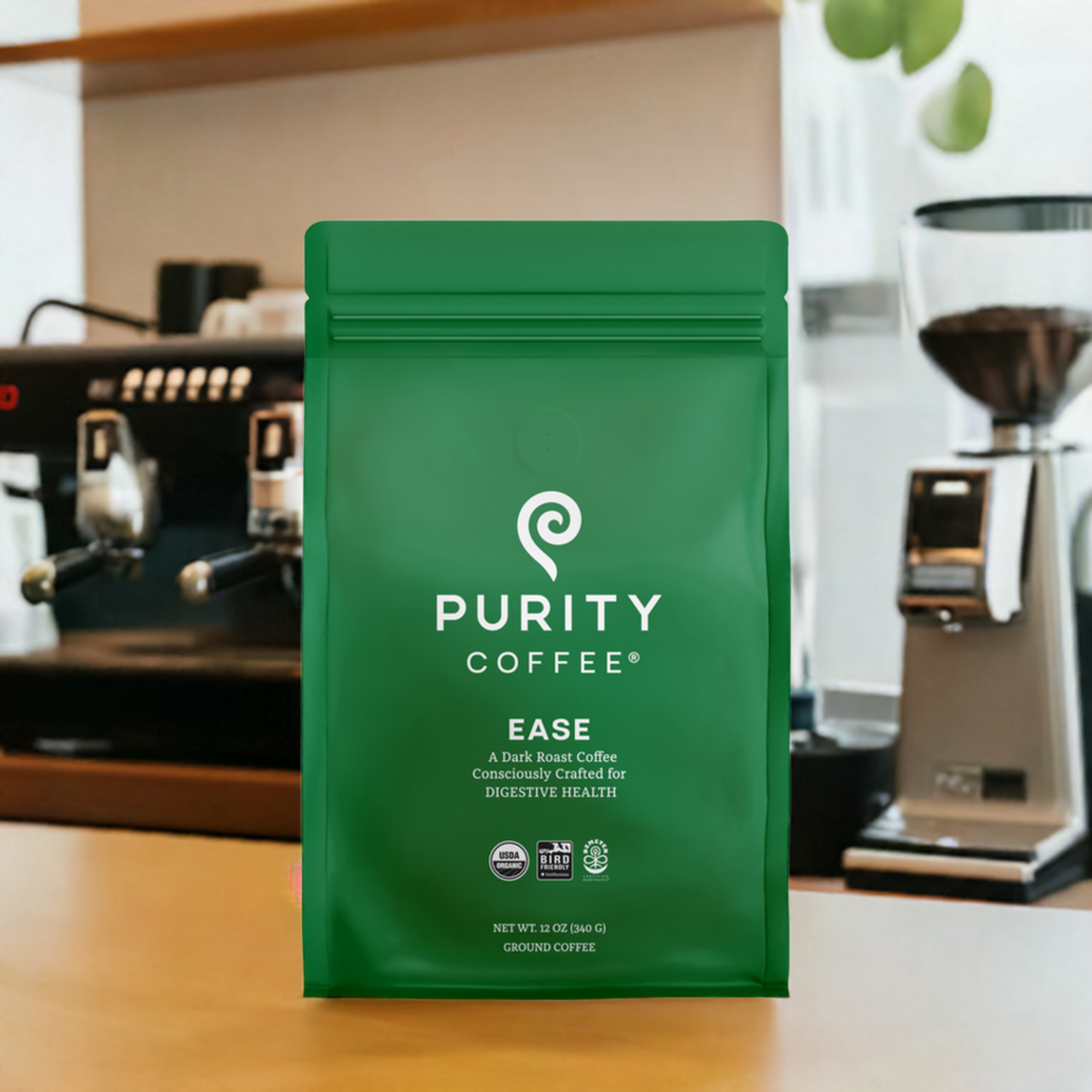Paquete de café molido Purity Coffee, tostado oscuro, diseñado conscientemente para apoyar la salud digestiva. El envase muestra el peso neto de 10 oz (340 g) y destaca su enfoque en la pureza y el bienestar. Ideal para amantes del café que buscan calidad y beneficios para la salud.