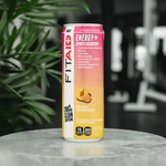 Front view of FitAid Energy Peach Mandarin can on a countertop with greenery in the background.

