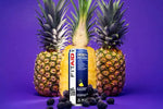 FitAid Energy cans in Blackberry Pineapple flavor displayed with sliced pineapples and blackberries on a vibrant purple background.

