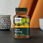 Gaia Herbs Gas & Bloating en un entorno elegante con fondo negro y detalles en naranja, destacando su fórmula de apoyo digestivo en presentación de 50 cápsulas veganas.