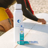 Liquid I.V. Passion Fruit hydration powder sticks displayed on a surfboard with branded water bottle, ideal for active lifestyle and beach hydration.