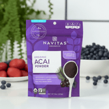 Straight-on view of the acai powder pouch with tropical props and clean kitchen background.

