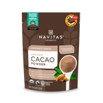 Front view of Navitas Organic Cacao Powder pouch with a spoonful of cacao and cinnamon sticks on the packaging.