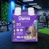 OWYN Plant-Based Protein Shake 20g – Cookies & Creamless flavor multipack on gym bench with fitness gear.
