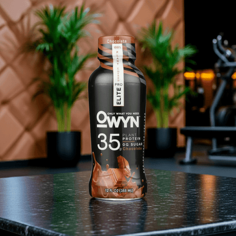OWYN Pro Elite Protein Shake 35g – High-protein plant-based shake in Chocolate flavor, placed on modern kitchen counter with fitness gear.