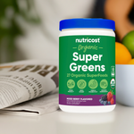 Nutricost Super Greens Powder beside a newspaper.