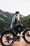 Man hydrating with reverse-osmosis aluminum water bottle while biking outdoors - eco-friendly reusable bottle

