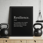 Resilience Framed Poster 12x16 – Motivational Wall Art for Success displayed in a home gym with kettlebells, featuring bold black-and-white typography. Ideal for inspiring strength and perseverance in workout or office spaces.