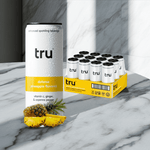 Tru Defense Sparkling Water Pineapple Flavor – Functional seltzer can with pineapple and vitamin C benefits on marble countertop, 12-pack box included.

