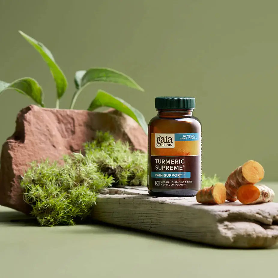 Gaia Herbs Turmeric Supreme® Pain - ACTIVE LIFESTYLE supplement bottle on wood with turmeric root and moss, ideal for natural pain relief support.