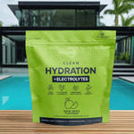 Clean Hydration + Electrolytes pouch displayed poolside with a sleek black glass-front house and tropical plants behind it, emphasizing a luxurious healthy lifestyle.