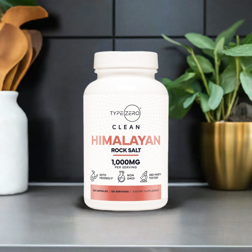 Frasco de Type Zero Clean Himalayan Rock Salt de 1,000 mg por porción, con 120 cápsulas, diseñado para apoyar la hidratación y el equilibrio mineral. Presentado sobre una superficie moderna con plantas y decoración minimalista en el fondo 