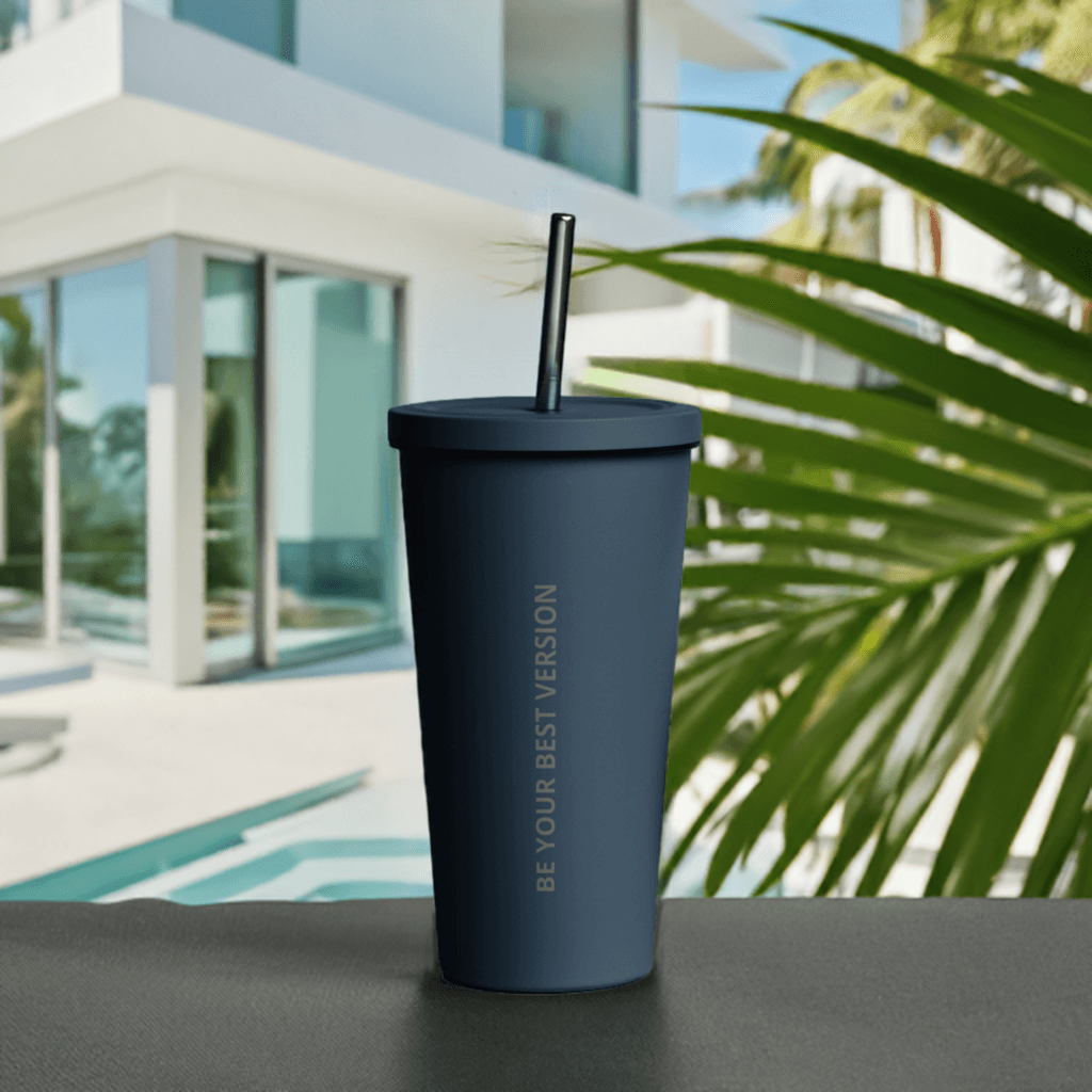 Navy blue Velite Armor Insulated Tumbler with straw, placed poolside, ideal for fashionable and functional beverage use.