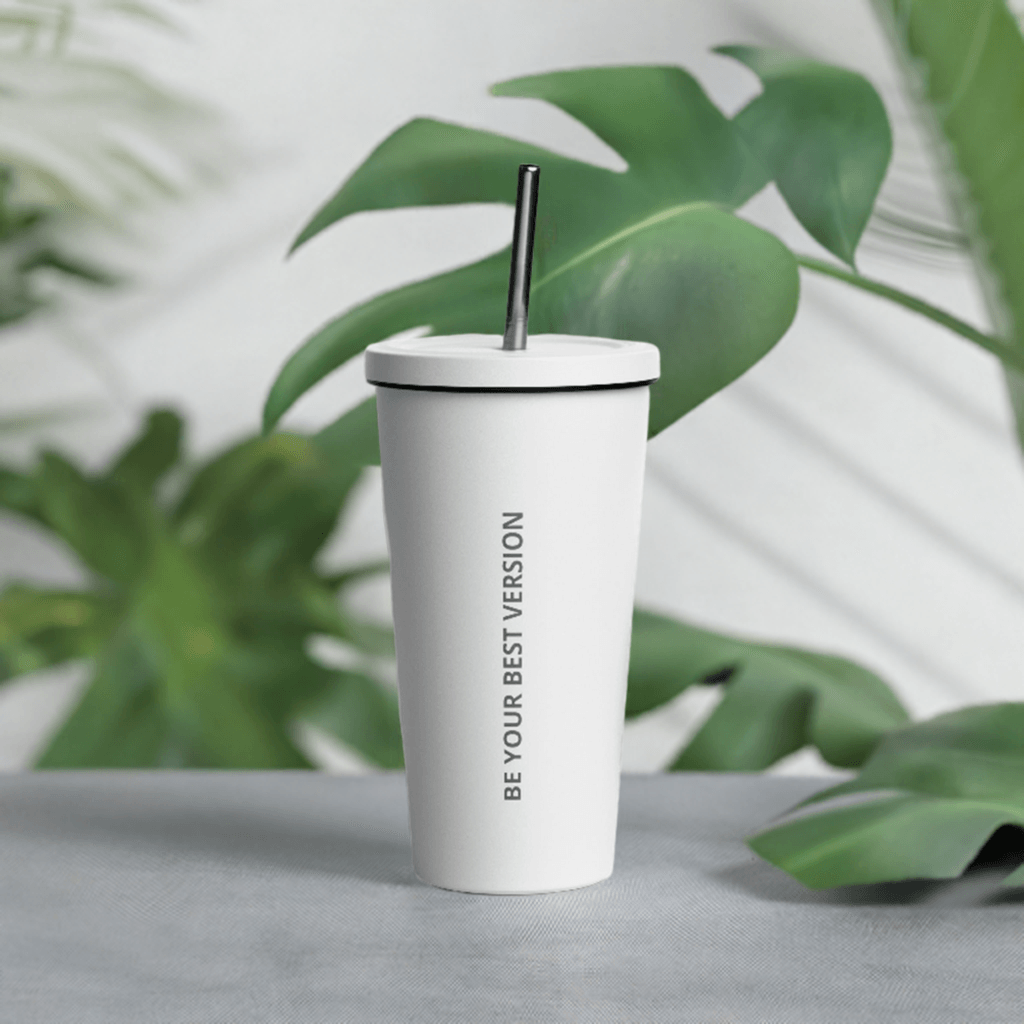 White Velite Armor Insulated Tumbler surrounded by tropical leaves, perfect for eco-conscious hydration in stylish settings.