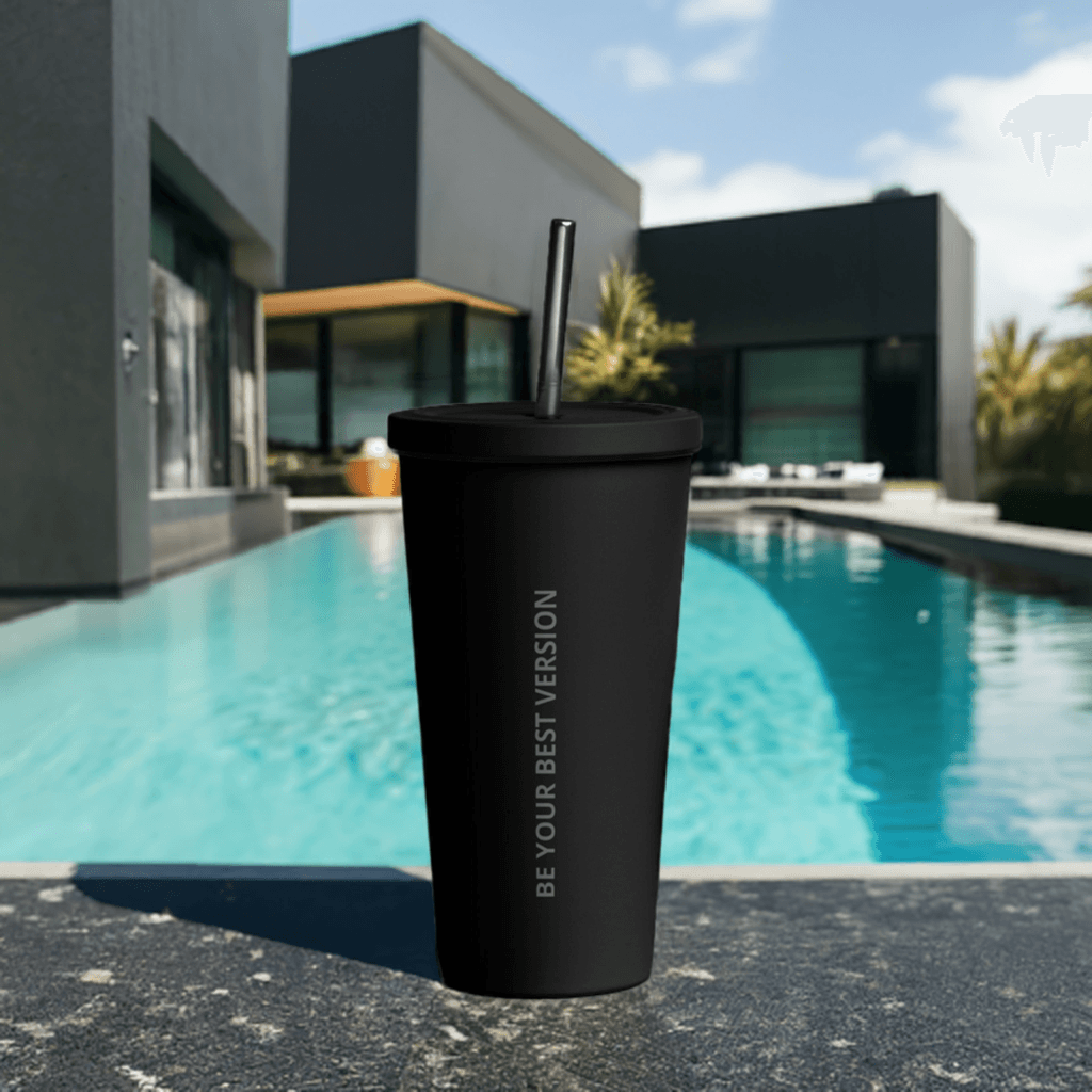 Black Velite Armor Insulated Tumbler on stone surface by pool, showcasing premium drinkware for modern outdoor living.