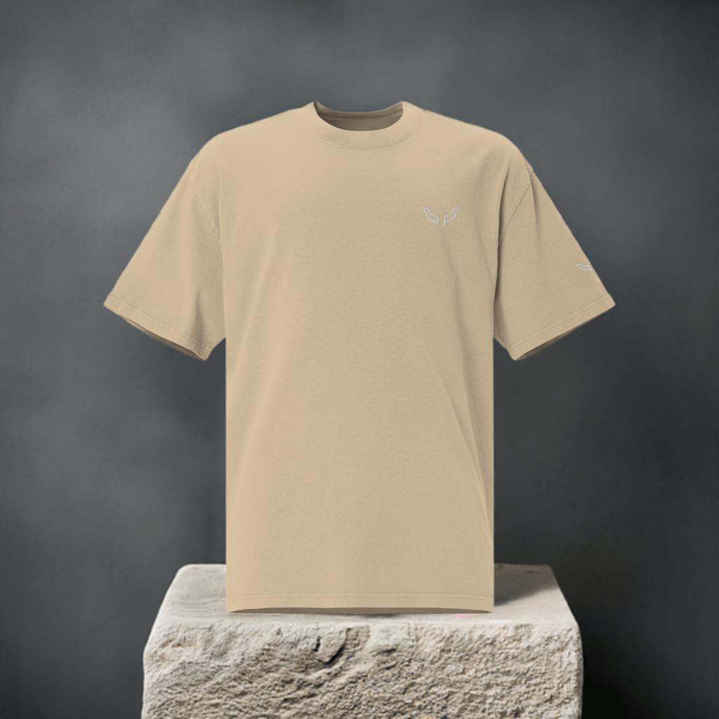 Velite Armor Oversized Embroidered Tee – Premium Heavyweight in beige displayed on stone pedestal, highlighting chest embroidery.