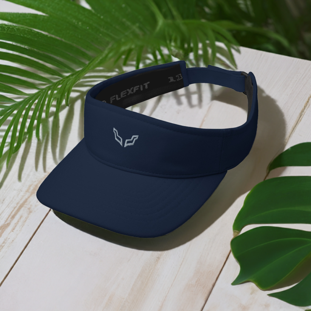 Velite Armor Performance Visor in navy blue with Flexfit band, shown on a tropical wood surface with green palm leaves. Lightweight and stylish design.