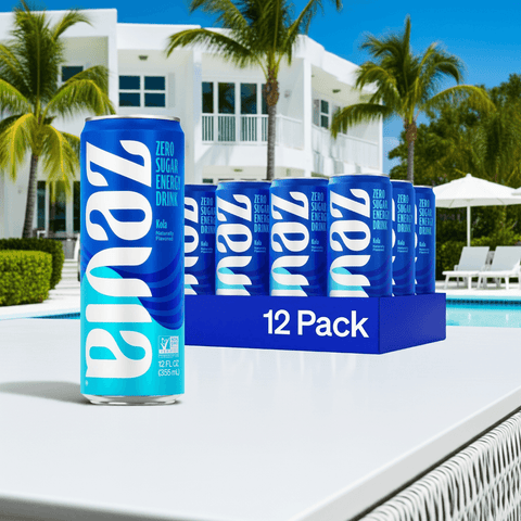 Zevia Kola Energy Drink – Zero Sugar, Zero Calories, 120 mg Caffeine in 12 oz cans, 12-pack displayed poolside with modern white villa background.