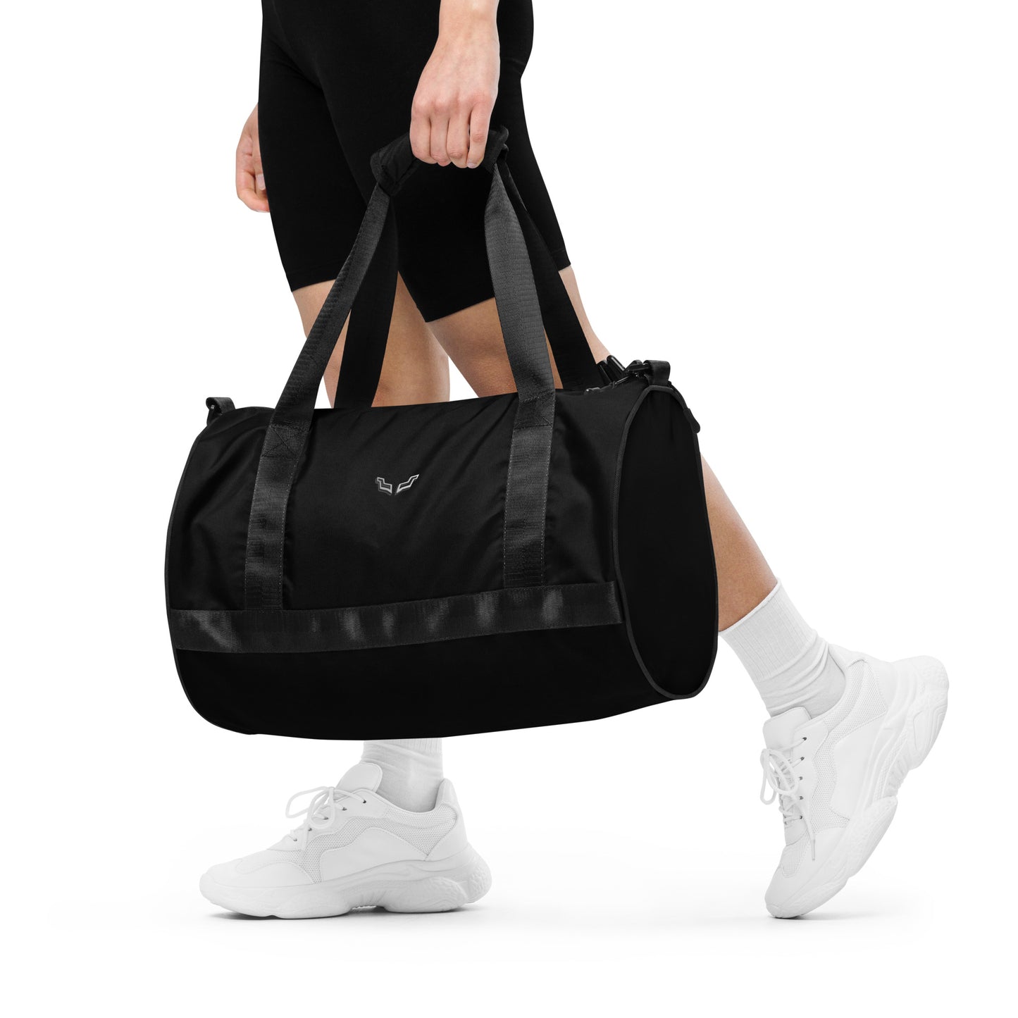 Velite Armor Gym Bag in sleek black carried by a person in athletic wear. Lightweight, water-resistant duffle ideal for workouts and travel.