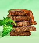 Close-up of Aloha Chocolate Mint Protein Bar showing the rich chocolate coating and smooth plant-based protein texture, paired with fresh mint leaves.
