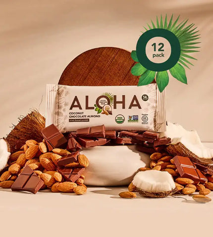 Aloha Coconut Chocolate Almond Protein Bar 12-pack display surrounded by chocolate pieces, almonds, and coconut, with USDA organic and non-GMO certifications.