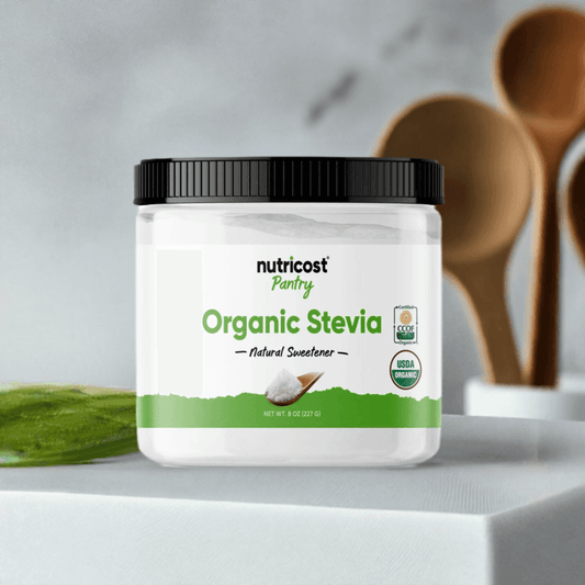 Nutricost Pantry Organic Stevia Powder 8oz jar on kitchen counter with wooden utensils, a pure natural sweetener for healthy recipes and drinks.