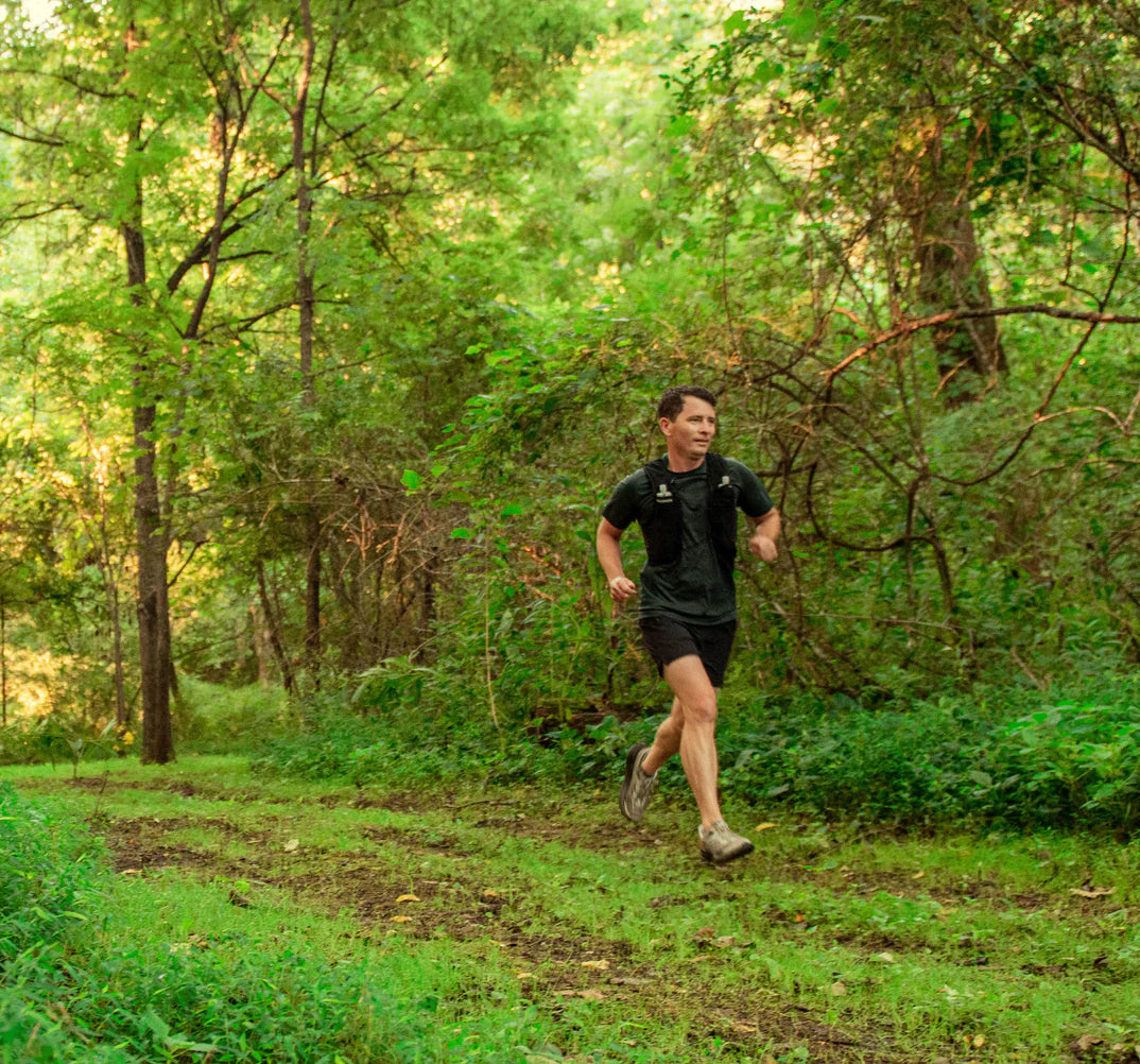 Runner in forest trail symbolizing active lifestyle supported by Turmeric Supreme® Pain - ACTIVE LIFESTYLE for muscle recovery and pain relief.