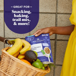 A person holding Navitas Organics Mulberries with a basket of fresh fruit, highlighting its use for snacking, baking, and healthy recipes.