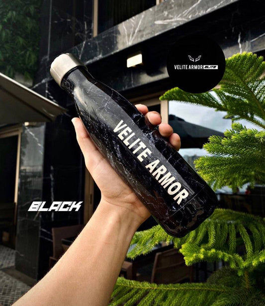 Velite Armor (ELITE) Water Bottle 17oz in black marble design, double-wall stainless steel, shown outdoors near a modern building.