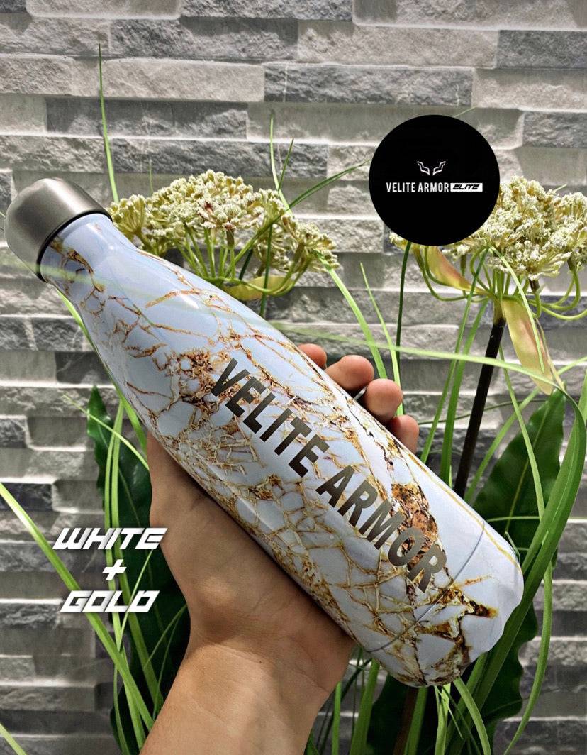 Velite Armor (ELITE) Water Bottle 17oz in white and gold marble design, eco-friendly accessory shown with floral background.